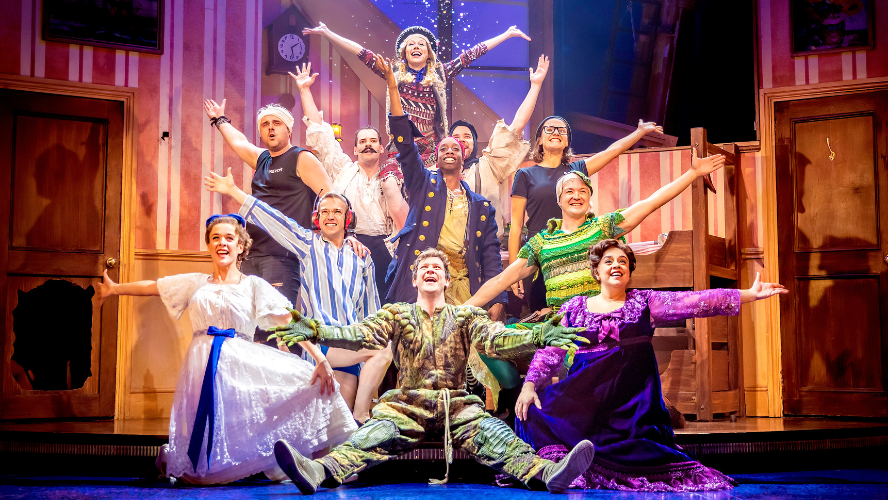 The cast of Peter Pan Goes Wrong centre stage with their arms outstretched
