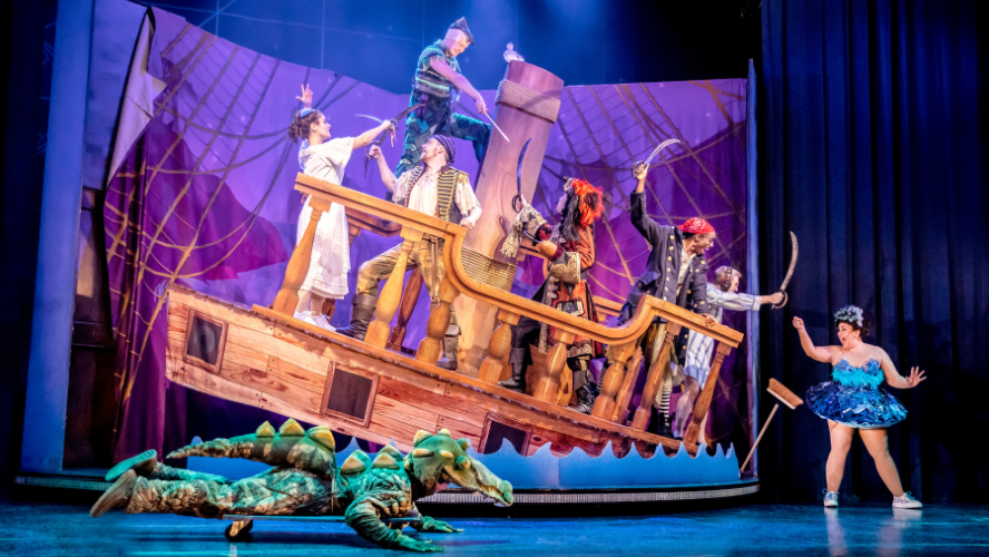 A pirate ship is askew as pirates fight peter pan and friends