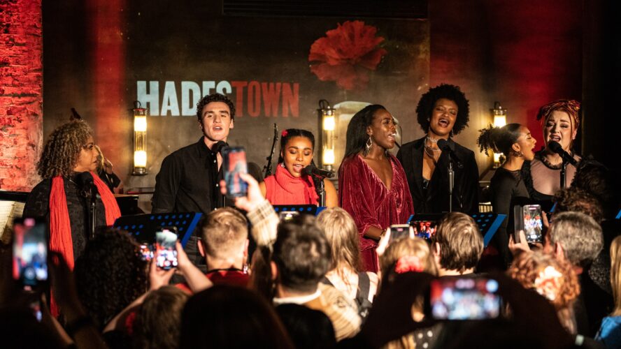 The cast of Hadestown singing concert-style in front of an audience.